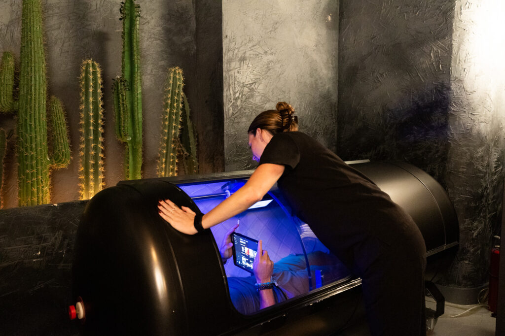 A patient lies down in a hyperbaric oxygen chamber as a form of athletic performance recovery in River North Chicago.
